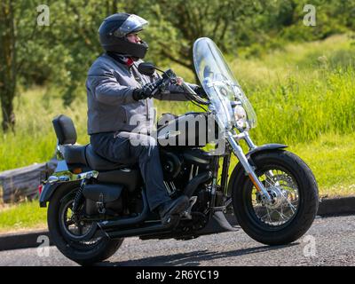 Stony Stratford, Großbritannien - Juni 4. 2023: 2015 HARLEY DAVIDSON 1200 klassisches Motorrad, das auf einer englischen Landstraße fährt. Stockfoto