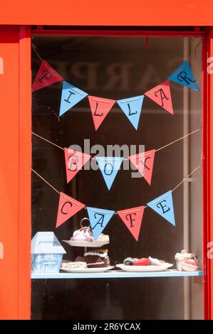 Bunting und Kuchen im Fenster des Pillar Box Cafés, Haltwhistle, Northumberland Stockfoto