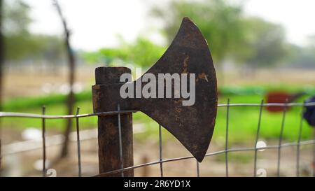 Traditionelle Tomahawk-Handaxt, die von den indianischen ureinwohnern verwendet wird, auf einem Eisenzaun im Freien ausgestellt. Stockfoto