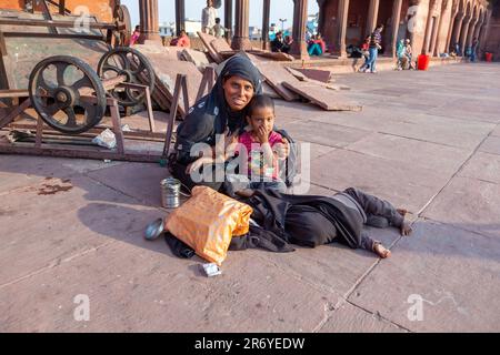 Delhi, Indien - 10. November 2011: Mutter mit Kind ruht auf dem Hof der Jama Masjid Moschee in Delhi. Jama Masjid ist die wichtigste Moschee der Alten Stockfoto