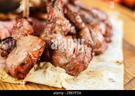 Ein zartes, geröstetes Schweinerippchen mit frisch zubereitetem Lavash im Innenbereich - perfekt für ein herzhaftes Abendessen. Stockfoto