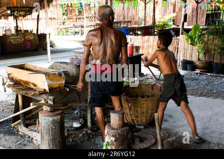 Thailändische alte Schmied- oder Metallschmied, die in der lokalen Schmiede-Werkstatt des Dorfes Bang Rachan antike Waffen aus Eisen und Stahl herstellen Stockfoto