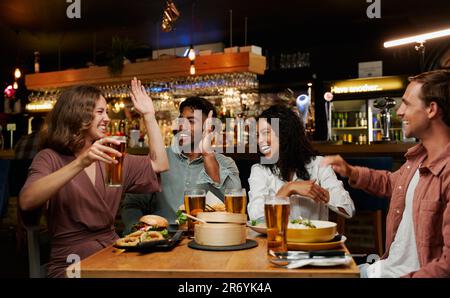 Junge, multiethnische Gruppe von Freunden in legerer Kleidung, die im Restaurant feiern Stockfoto