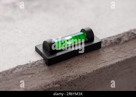 Bau-Wasserwaage mit grüner Kuppel auf Betonoberfläche Stockfoto