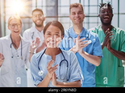 Professionelle multinationale Ärzte applaudieren vor der Kamera. Diagnosediskussion Stockfoto