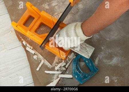 Worker cutting decorative wall tile indoors, closeup Stockfoto
