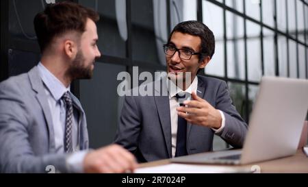 Eine Gruppe von Kollegen aus der Unternehmensbranche, die im Sitzungssaal ein Meeting am Tisch abhalten. Stockfoto