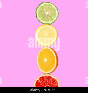 Stapel verschiedener frischer Zitrusfrüchte auf pinkfarbenem Hintergrund Stockfoto