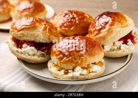 Frisch gebackene Soda-Wasser-Scones mit Preiselbeermarmelade und Butter auf dem Tisch, Nahaufnahme Stockfoto