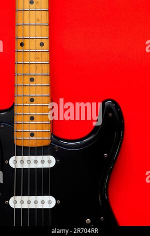 Elektrische Gitarre auf rotem Hintergrund. Stockfoto