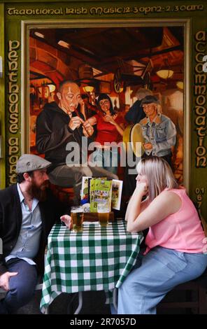 Ein Paar, das sein Bier in der Oliver St. genießt John Gogarty Bar & Restaurant in Temple Bar, Dublin, Irland. Stockfoto