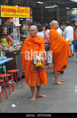 Ein thailändischer buddhistischer Mönch segnet die Einheimischen und empfängt Almosen im Rahmen eines morgendlichen Rituals. Foto in Bangkok, Thailand. Stockfoto