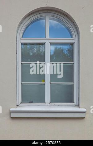 Nahaufnahme eines weißen, gerahmten Holzfensters auf einem Steingebäude. Stockfoto