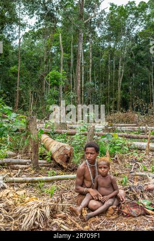 Frau des Korovai-Stammes mit einem Kind. Stamm der Korowai (Kombai, Kolufo). 10. Juni 2016 in Onni Village, Neuguinea, Indonesien Stockfoto