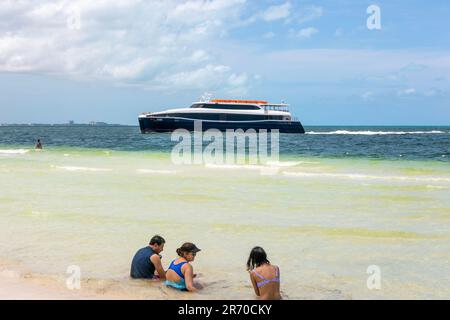 Xcaret-Fähre von Isla Mujeres mit Menschen, die im Meer sitzen, Cancun, Quintana Rood, Mexiko Stockfoto