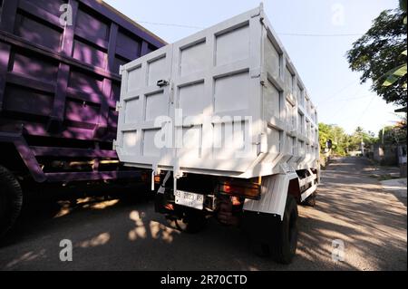 10. Juni 2023, Kulonprogo, Yogyakarta, Indonesien: Ein Mini-Lkw fährt am 12. Juni 2023 vor einem echten Lkw im Dorf eines Einwohners in Kulonprogo, Yogyakarta. Der Lkw verwendet einen modifizierten Motorradmotor. Der Spielzeugwagen ist so konstruiert, dass er im Allgemeinen einem Lkw ähnelt, hat jedoch wesentlich kleinere Abmessungen mit Vorwärts-, Rückwärts- und Hubfunktionen hinter dem Bett. Ein junger Mann namens Imam, Eigentümer von Rimbono Garage, sagte, dass der Zweck der Herstellung des Mini-Lkws anfangs nur darin bestand, Fananfragen in sozialen Medien zu erfüllen. Denn vor der Herstellung von Spielzeugautos war die Karosserie des Lkws rein handgefertigt Stockfoto