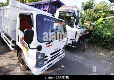 10. Juni 2023, Kulonprogo, Yogyakarta, Indonesien: Ein Mini-Lkw fährt am 12. Juni 2023 vor einem echten Lkw im Dorf eines Einwohners in Kulonprogo, Yogyakarta. Der Lkw verwendet einen modifizierten Motorradmotor. Der Spielzeugwagen ist so konstruiert, dass er im Allgemeinen einem Lkw ähnelt, hat jedoch wesentlich kleinere Abmessungen mit Vorwärts-, Rückwärts- und Hubfunktionen hinter dem Bett. Ein junger Mann namens Imam, Eigentümer von Rimbono Garage, sagte, dass der Zweck der Herstellung des Mini-Lkws anfangs nur darin bestand, Fananfragen in sozialen Medien zu erfüllen. Denn vor der Herstellung von Spielzeugautos war die Karosserie des Lkws rein handgefertigt Stockfoto