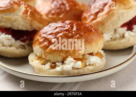 Frisch gebackene Soda-Wasser-Scones mit Preiselbeermarmelade und Butter auf dem Tisch, Nahaufnahme Stockfoto