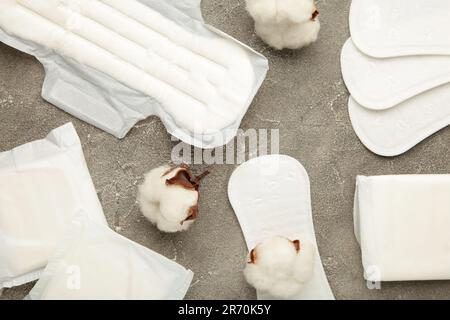 Hygienepads mit Baumwolle auf grauem Hintergrund. Draufsicht Stockfoto