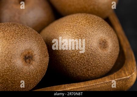 Eine Gruppe reifer, ganzer Kiwis, gelber, schöner Kiwis, nicht grün Stockfoto