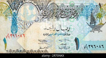 Ein großes Fragment der Vorderseite der 1-Riyal-Bargeld-Banknote von Katar enthält verzierte Säulen, Bögen, Segelboote, Palmen, cro Stockfoto