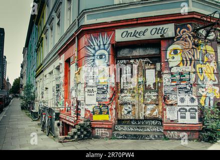 Ein Foto eines lebendigen Gebäudes mit bunt bemalten Wänden und einer Fülle von Werbungen, die seitlich in Hamburg ausgestellt sind Stockfoto