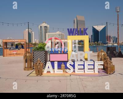 20. März 2023, Dubai, Vereinigte Arabische Emirate: Blick über den Creek in Richtung Deira mit Hashtag-Schild für Ramadan auf der Promenade von Al Seef Stockfoto