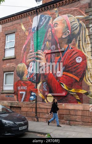 Ein Wandgemälde von Missy Bo Kearns des FC Liverpool, das die Trophäe der Frauenmeisterschaft hebt, auf der Seite eines Hauses in der Tancred Road, Anfield, von Paul Curtis. Stockfoto