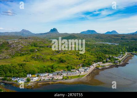 Blick aus der Vogelperspektive auf das Dorf Lochinver mit den Bergen von Assynt/Coigach in der Ferne, schottische Highlands, Schottland, Großbritannien Stockfoto