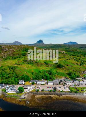 Blick aus der Vogelperspektive auf das Dorf Lochinver mit den Bergen von Assynt/Coigach in der Ferne, schottische Highlands, Schottland, Großbritannien Stockfoto