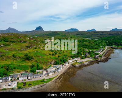 Blick aus der Vogelperspektive auf das Dorf Lochinver mit den Bergen von Assynt/Coigach in der Ferne, schottische Highlands, Schottland, Großbritannien Stockfoto