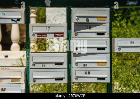 Verschiedene farbige Briefkästen am Straßenrand Stockfoto