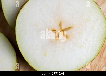 Zerstückelte Birne auf dem Tisch, reife Birne in Scheiben geschnitten Stockfoto