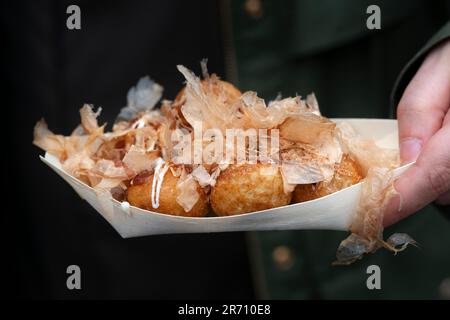 Italien, Street Food Festival, Japanes Food, Person Holding Takoyaki Famous Japanese Snack Food oder Octopus Ball Stockfoto