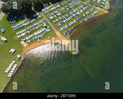 Ein Luftblick auf eine Küstenlandschaft mit einer Reihe von Booten, die auf dem Grasstrand geparkt sind Stockfoto