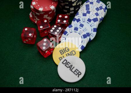 Rote Würfel und Spielmarken (Chips) auf einer grünen Tischplatte Stockfoto