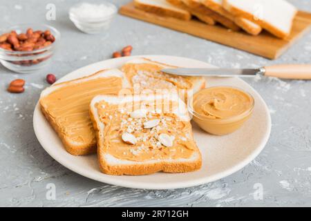 Erdnussbutter-Sandwiches oder Toast auf hellem Tischhintergrund. Frühstück. Vegetarisches Essen. Amerikanische Küche, Top-View mit Kopierbereich. Stockfoto