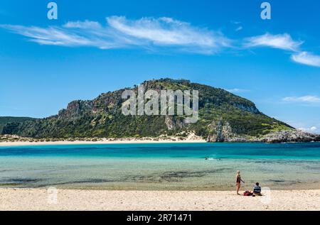 Strandbesucher am Voidokillia Beach, Frühling, Old Navarino Castle (Paliokastro) auf einem Hügel in dist, nahe Pylos, Peloponnes, Griechenland Stockfoto