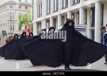 London, England, Großbritannien. 12. Juni 2023. Aktivisten, bekannt als Oil Slicker, passieren Guildhall. Extinction Rebellion inszenierte eine Demonstration in der Londoner City, um gegen die Übernahme der COP 28 durch Ölgesellschaften und gegen die Finanzierung fossiler Brennstoffe zu protestieren. (Kreditbild: © Vuk Valcic/ZUMA Press Wire) NUR REDAKTIONELLE VERWENDUNG! Nicht für den kommerziellen GEBRAUCH! Kredit: ZUMA Press, Inc./Alamy Live News Stockfoto