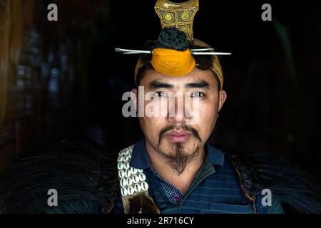 Porträt eines jungen Nishi-Mannes in traditionellem Kopfkleid mit dem Schnabel des Hornbill-Vogels, Arunachal pradesh, Nordosten Indiens Stockfoto