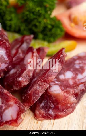 Geschnittene Wurst aus Fleischstücken mit Speck, köstliche frische Wurst mit Gewürzen Stockfoto