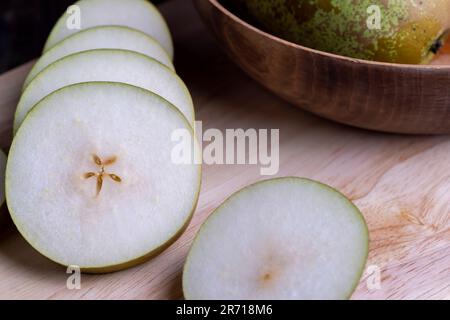 Zerstückelte Birne auf dem Tisch, reife Birne in Scheiben geschnitten Stockfoto