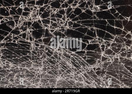 Verschmutztes Glas, das in eine große Anzahl von Teilen zerbrochen ist, ein Stück Glas mit vielen Rissen und gebrochenen Teilen Stockfoto