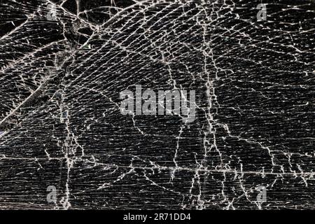 Glas zerbrochen in eine große Anzahl von Stücken und Rissen, ein Stück Glas mit einer großen Anzahl von Rissen und gebrochenen Teilen Stockfoto