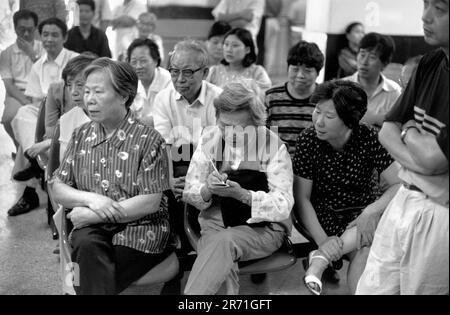 Shanghai China 2000.. Man sagt, dass 60 Millionen Anteilseigner in China einen direkten Vorgeschmack auf den Kapitalismus bekommen. Hier werden begeisterte Kunden am Ende des Handelstages von ihrem Makler über die aktuellen Börsenbewegungen informiert. Für ältere Menschen und entlassene Arbeitnehmer stellt die Börse nicht nur eine potenzielle Einkommensquelle dar. 2000s HOMER SYKES Stockfoto