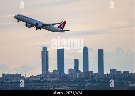 Nach dem Flug fliegt ein Airbus A321 von Turkish Airlines über die Wolkenkratzer von Madrids Skyline, auch bekannt als „Four Towers Business Area“ Stockfoto