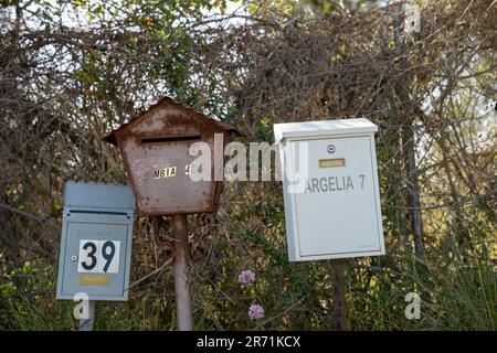 Verschiedene farbige Briefkästen am Straßenrand Stockfoto