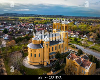 FOT, Ungarn - Luftaufnahme der römisch-katholischen Kirche der Unbefleckten Empfängnis (Szeplotlen Fogantatas Templom) in der Stadt FOT auf einem sonnigen Sort Stockfoto