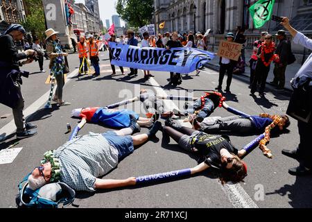 England, London, Westminster, Demonstranten, die vor der Downing Street marschieren, liegen auf dem Boden und verbinden Waffen. Stockfoto