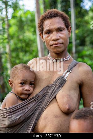 Frau des Korovai-Stammes mit einem Kind. Stamm der Korowai (Kombai, Kolufo). 10. Juni 2016 in Onni Village, Neuguinea, Indonesien Stockfoto